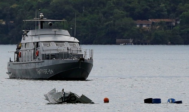 Destroço do avião que caiu com o ministro do STF Teori Zavascki a bordo é visto diante de um navio da Marinha nesta sexta-feira (20), um dia após a queda, que está sob investigação (Foto: Bruno Kelly/Reuters)